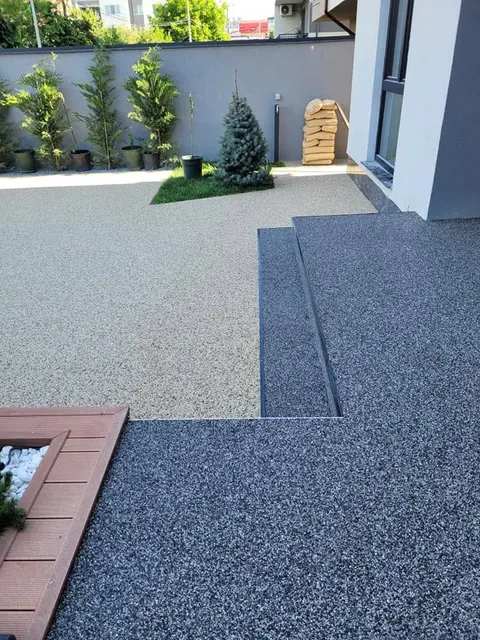 Terasă gri cu bordură antracit și jardiniere din lemn roșcat