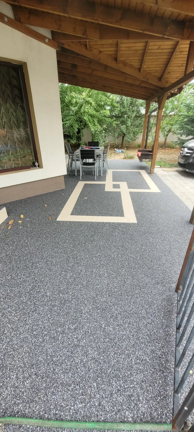 Terasă acoperită cu covor de piatră gri și intarsie decorativă geometrică crem