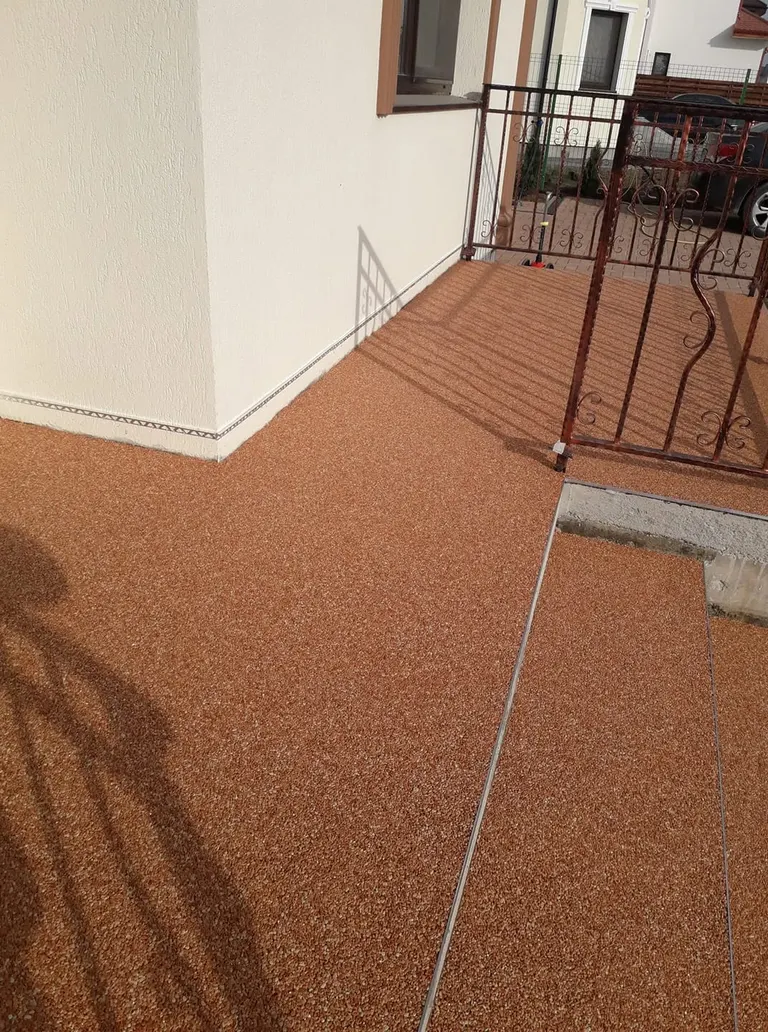 Terasă din covor de piatră teracotă cu balustradă din fier forjat