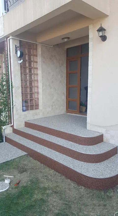 Trepte de intrare din covor de piatră gri cu borduri maro, cu forme rotunjite